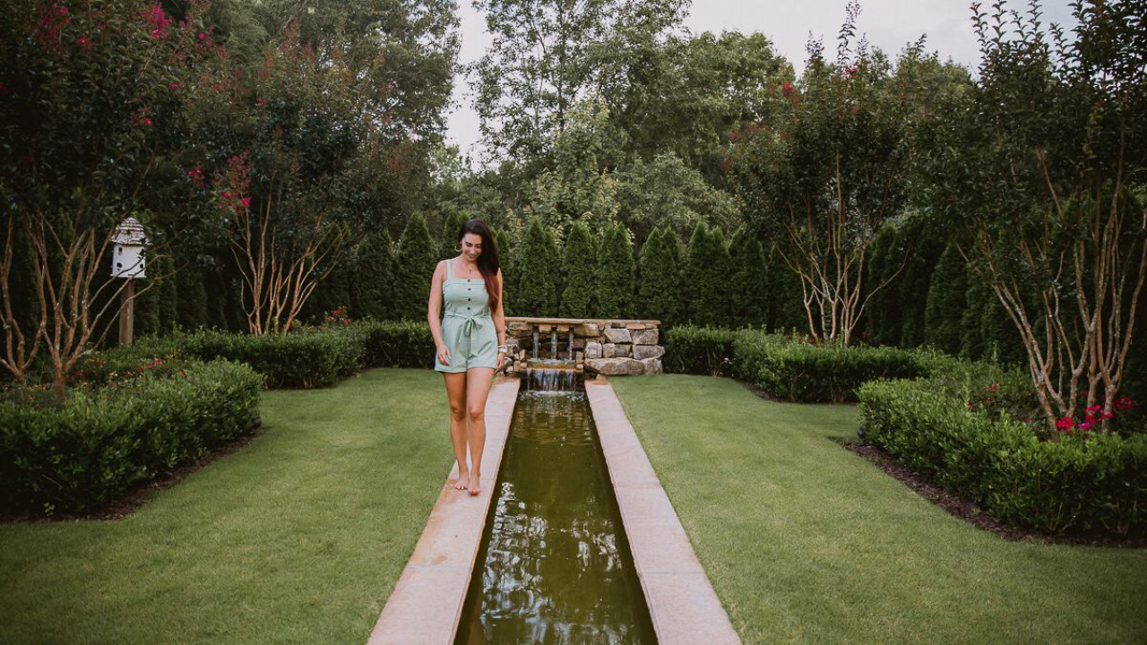 CeCe wearing a green jumpsuit, walking along a pool